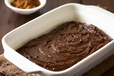 Basic homemade brownie or chocolate cake dough in greased and floured baking pan, photographed on...