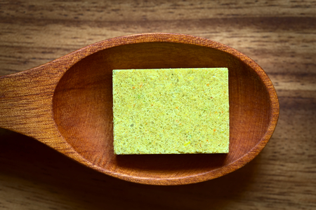 Vegetable bouillon, stock or broth cube on wooden spoon, photographed overhead with natural light (Selective Focus, Focus on the top surface of the cube)の写真素材