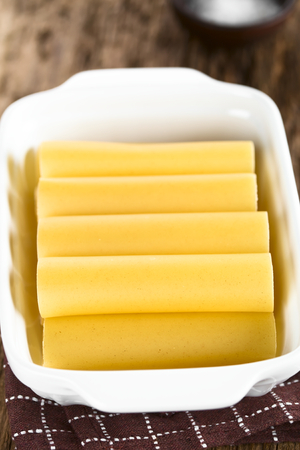 Raw cannelloni pasta in baking dish (Selective Focus, Focus on the cannelloni in the front)の写真素材