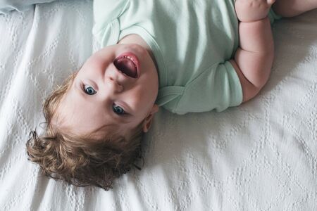 Mother and baby working on the laptop on the bed in bedroomの写真素材