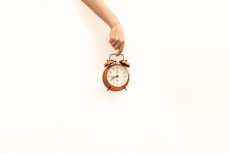 Hand holding bronze watch on white paper background.の写真素材