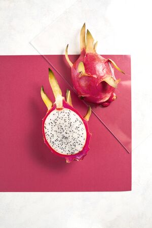 Dragon fruit cut in half on colorful red backgroundの写真素材
