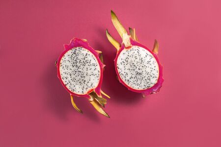 Dragon fruit cut in half on colorful red backgroundの写真素材