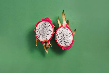 Dragon fruit cut in half on bright green backgroundの写真素材