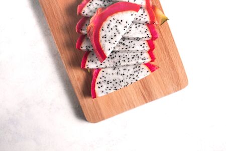 Dragon fruit sliced in on wooden cutting board on white background