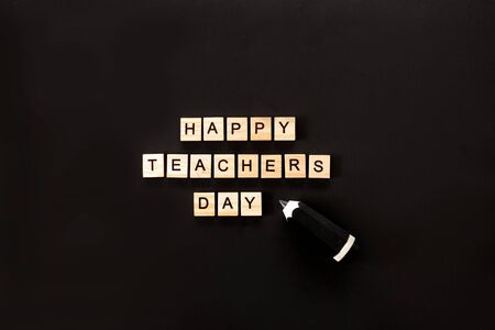 Wooden letters spelling Happy teachers day on green dark backgrundの写真素材