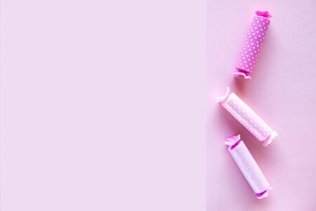Three candy in polca dot wrapper on pink background.の写真素材
