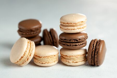 Vanilla, chocolate and rasberry macaroons on light gray background