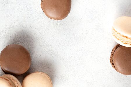 vanilla and chocolate macaroons arranged as a frame on light background with copy spaceの写真素材