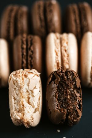 Light cream and chocolate macaroons on black backgroundの写真素材