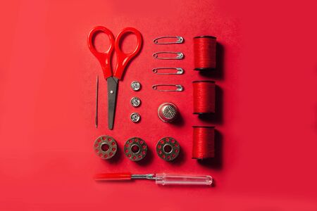 Sewing kit accessories and tools for needle work in red. Tape measure, pins, scissors, buttons,...