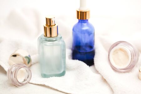 Set of colorful glass bottles with skin care products on white background with copy space. Face serums, acids and packages for essencial oils.の写真素材