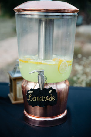 Three jars with refreshing driks - lemonade, water and ice tea on navy blue tableclothの写真素材