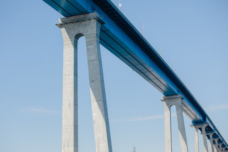 Detail of modern concrete tall bridge against blue sky background with copy spaceの写真素材