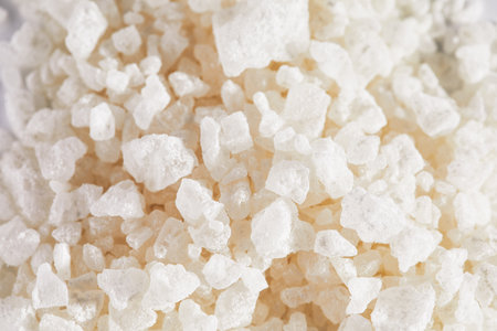 Macro shot of bath sea salt crystals on white background wiht copy space