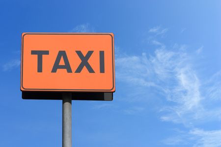 taxi sign over blue sky の写真素材