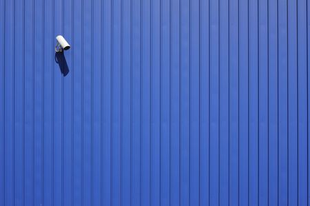security camera on blue metallic wall with copy spaceの写真素材