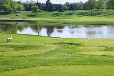 luxury golf club with flags and lake in backgroundの写真素材