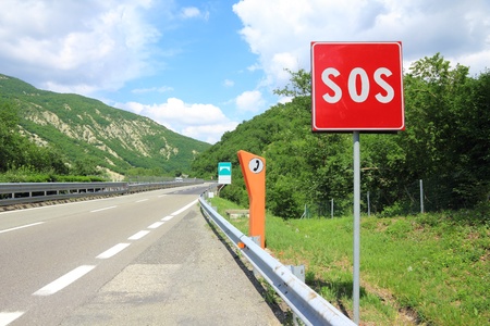 SOS sign and phone box on highwayの写真素材
