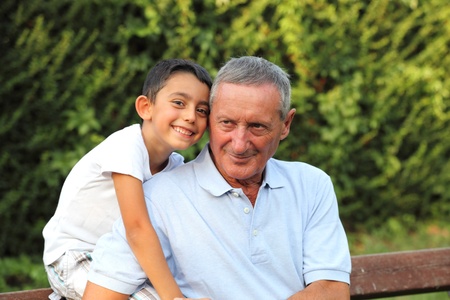 grandson smiling with grandfather in a parkの写真素材