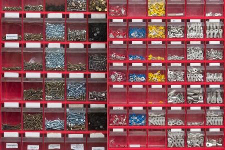 Red box  background with many different screws  