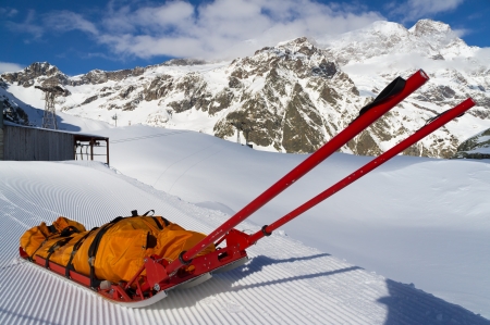 Empty mountain rescue sled over snow on mountainの写真素材