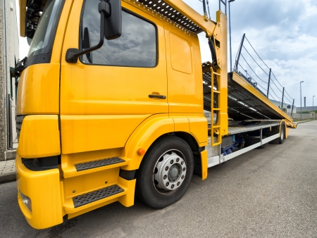 yellow car carrier truck with raised rampの写真素材