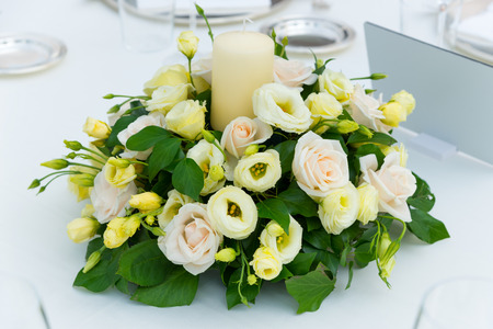 white pink and yellow roses flowers on table for a weddingの写真素材