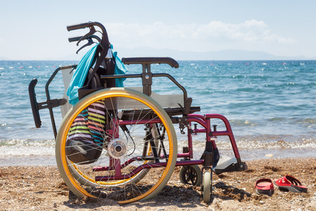 wheelchair on the beach against blue sea in summerの写真素材