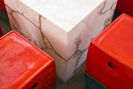 A white marble table with red ceramic benches in a restaurantの写真素材