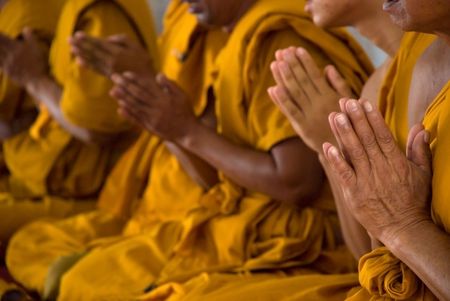The hands of praying Thai Buddhist monks.の写真素材