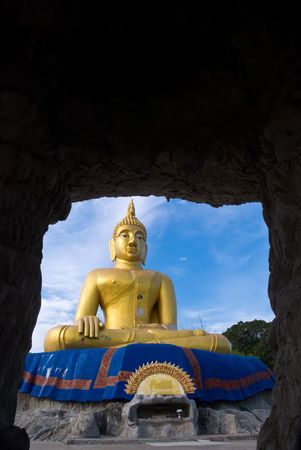 A large gold Buddha statue viewed from a caveの写真素材