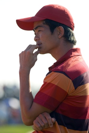 Chinese professional golfer Liang Wen-chong observing the last stages of competition at the Royal Trophy Tournament which opposed Europe versus Asia at the Black Mountain Golf Club in Hua Hin, Thailand, on January 9, 2011.のeditorial素材