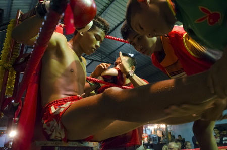 Hua Hin, Thailand - January 8, 2016: A Muay Thai boxer rests between two rounds as he receives instructions from his trainer at the boxing stadium in Hua Hin, Thailand on January 8, 2016. Muay Thai boxing is considered by many as the national sport of Thaのeditorial素材
