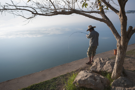 Phayo, Thailand - December 29, 2011: A man fishes at a lake in Phayo, Thailand on December 29, 2011.のeditorial素材