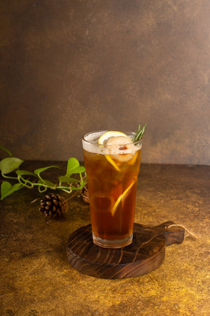 freshly lemon tea made with ice in glass with slice of lemon and rosemary, on rustic wooden tray and authentic backgroundの写真素材