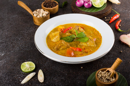 yellow curry fish or gulai ikan with tilapia fish seasoned with fresh herbs and spicesの写真素材