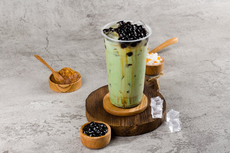 Boba or tapioca pearls is taiwan bubble milk tea in plastic cup with matcha flavor on texture  background, summers refreshment.の写真素材