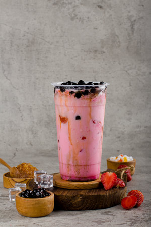 Boba or tapioca pearls is taiwan bubble milk tea in plastic cup with Strawberry jam flavor on texture  background, summers refreshment.の写真素材