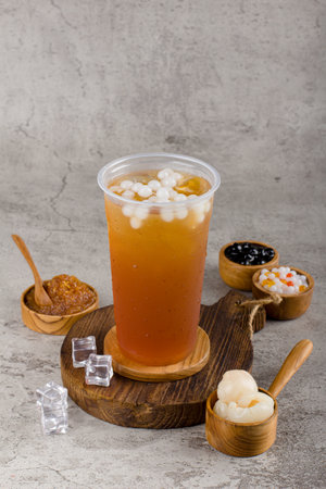 Boba or tapioca pearls is taiwan bubble milk tea in plastic cup with camomile tea flavor on texture  background, summers refreshment.の写真素材