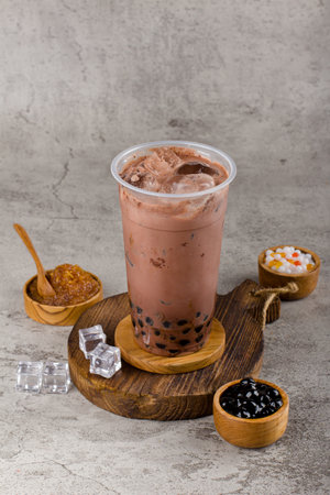 Boba or tapioca pearls is taiwan bubble milk tea in plastic cup with dark chocolate flavor on texture  background, summers refreshment.の写真素材