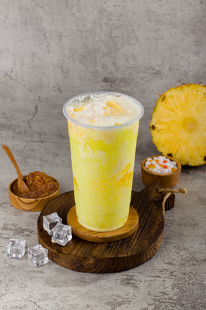 Boba or tapioca pearls is taiwan bubble milk tea in plastic cup with Pineappple flavor on texture  background, summers refreshment.の写真素材