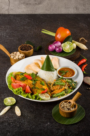 Chicken curry with rice and vegetables on black background, Thai food.の写真素材