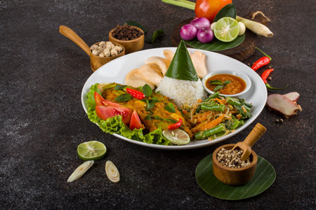 Thai curry chicken with rice and vegetables on black stone background.の写真素材