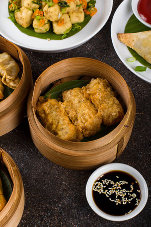 Dim sum in bamboo steamer on black stone background, top viewの写真素材