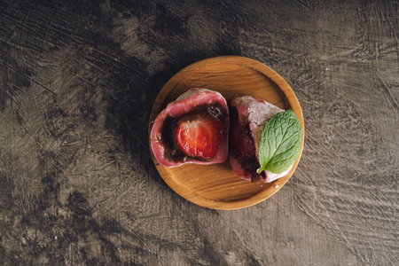 Japanese mochi or rice cake filled with red bean and strawberry, mint leaves on top. Japan traditional rice cake.の写真素材