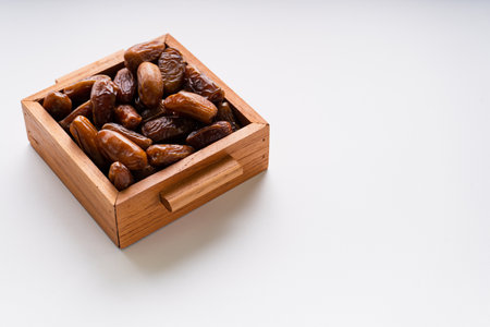 Dried dates fruit in wooden tray isolated on white background.の写真素材