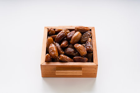 Dried dates fruit in wooden tray isolated on white background.の写真素材