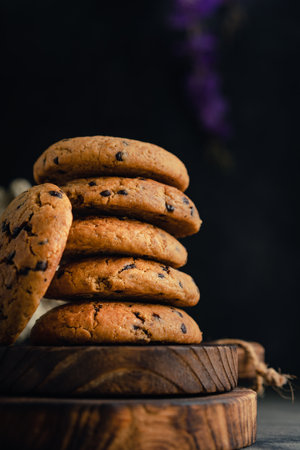 Homemade chocolate chip cookies on rustic wooden coaster and abstract backgroundの写真素材