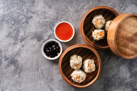 Chinese steamed dumplings or  Dim Sum in bamboo steamer on dark abstract backgroundの写真素材